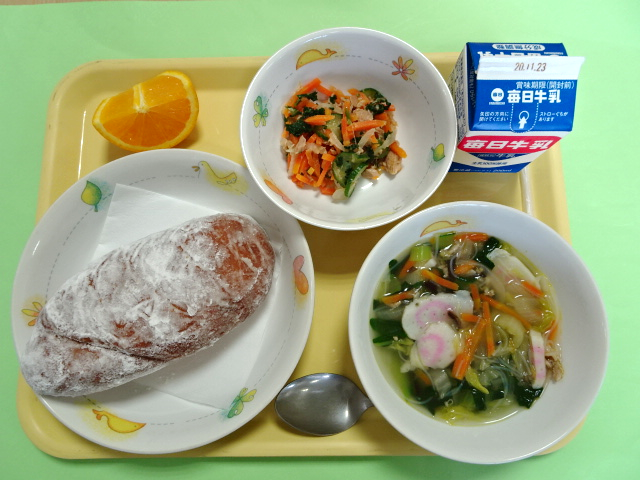 揚げパンや汁物、おひたし、みかん、牛乳パックなどの給食の写真