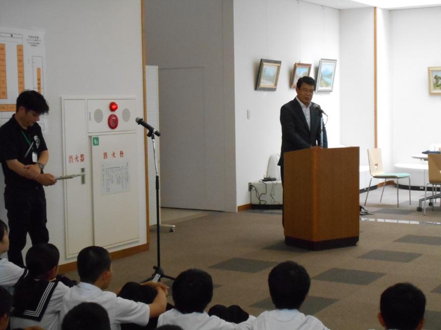 会場の生徒らの前で挨拶をする市長の写真