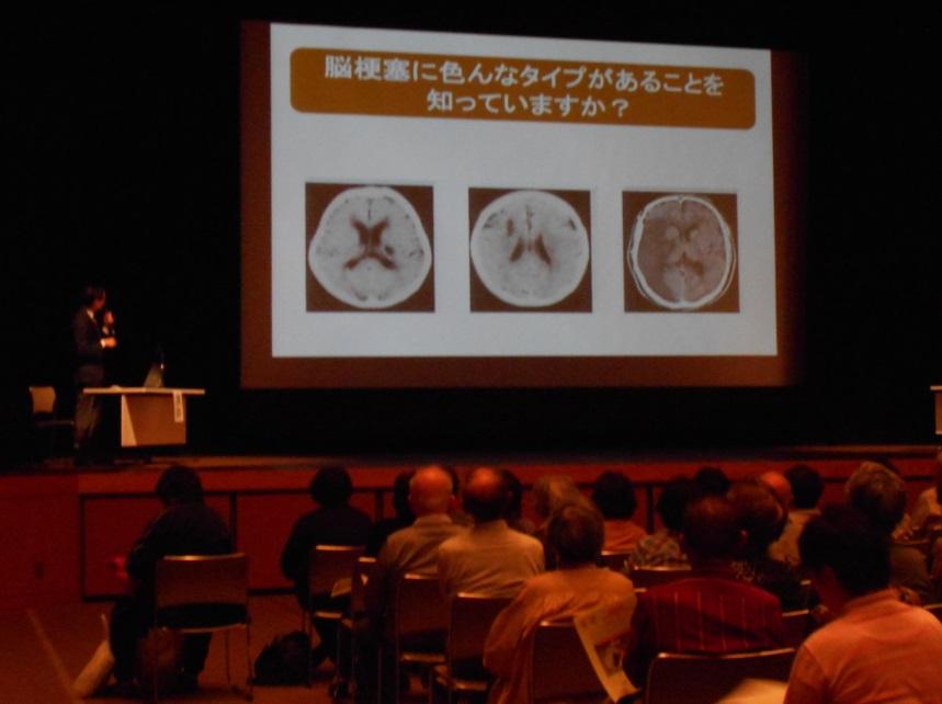 大型スクリーンを使いながら行われる講座に耳を傾ける参加者らの写真