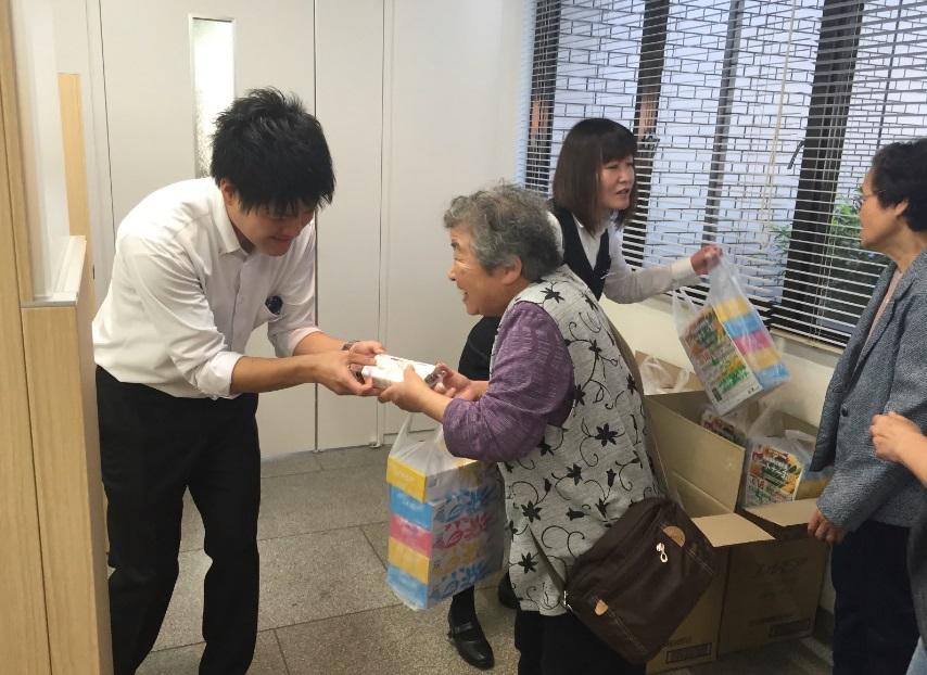 式典に訪れた女性がプレゼントを貰っている様子の写真