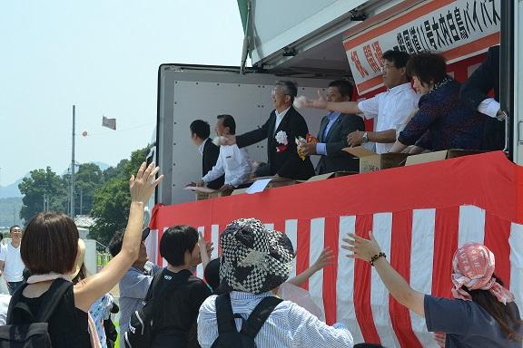 持ち投げをしている市長らに手を伸ばす民衆の様子の写真