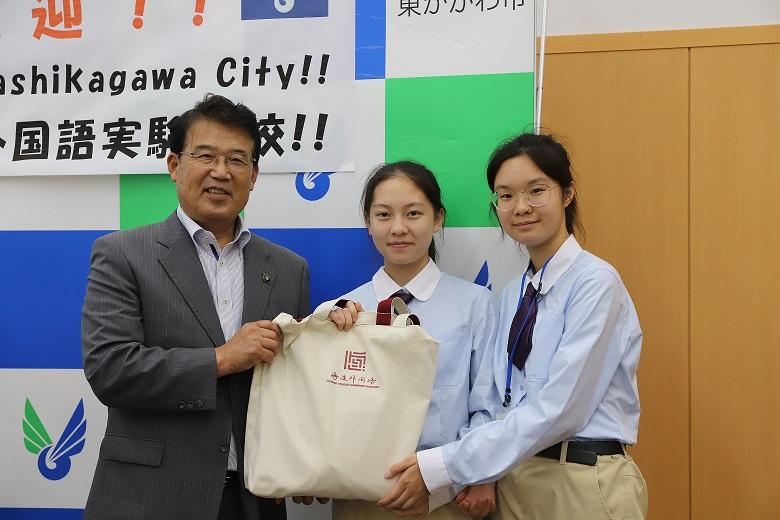 記念品に手を添えた市長と生徒2名の写真