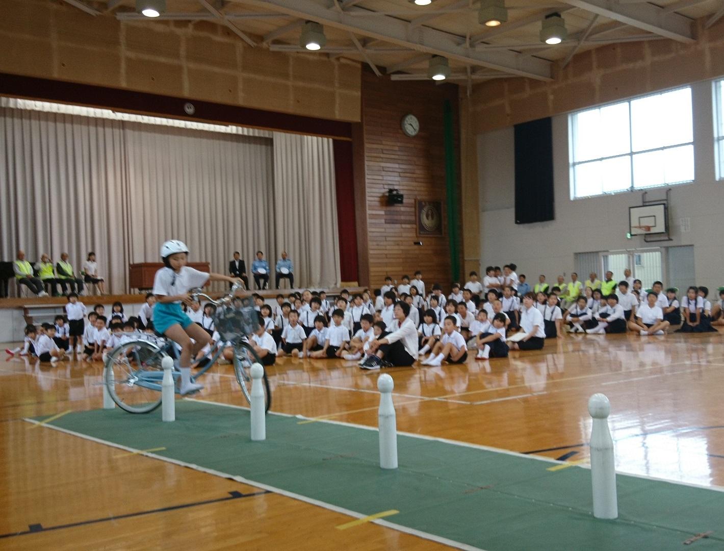 選手が児童らの前でジグザク走行を披露している様子の写真