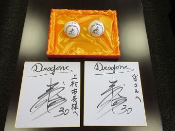 色紙と野球ボールに書かれた三好選手のサインの写真