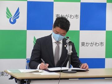 締結書にサインをしている市長の様子の写真