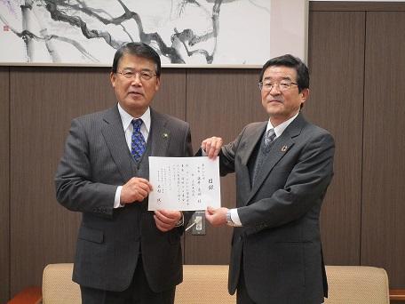 贈呈式にてコープかがわの代表者と市長が目録に手を添えた写真