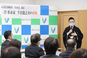 半沢龍之介さんがマイクを持って話をしている写真
