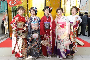 金屏風の前にて、笑顔でピースサインの振袖姿の新成人方々の集合写真