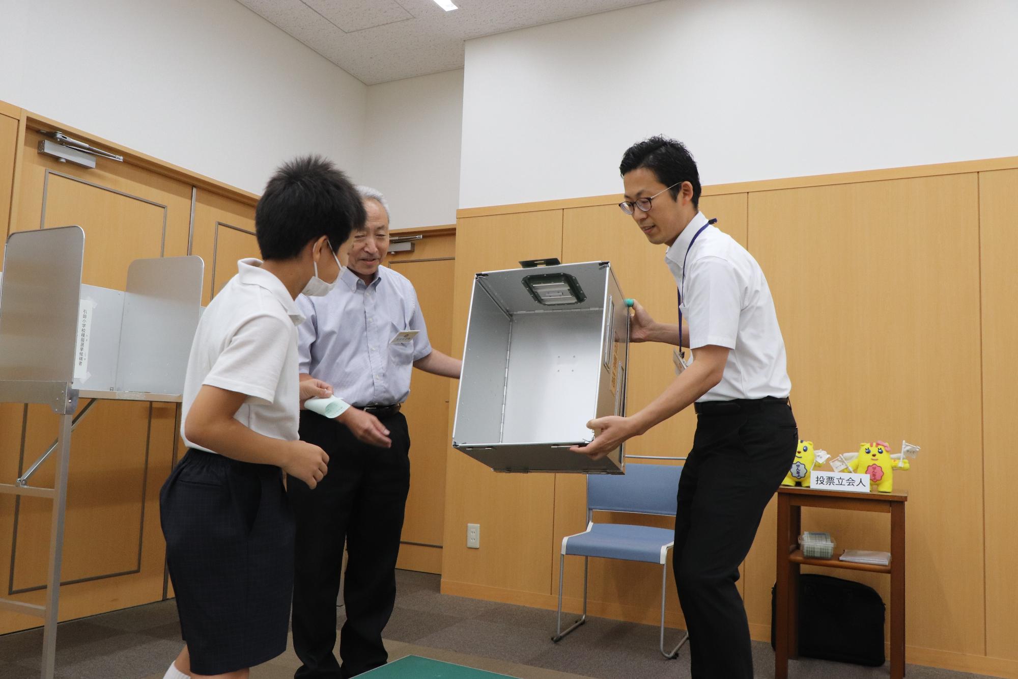 投票所や投票の流れについて説明を受ける児童