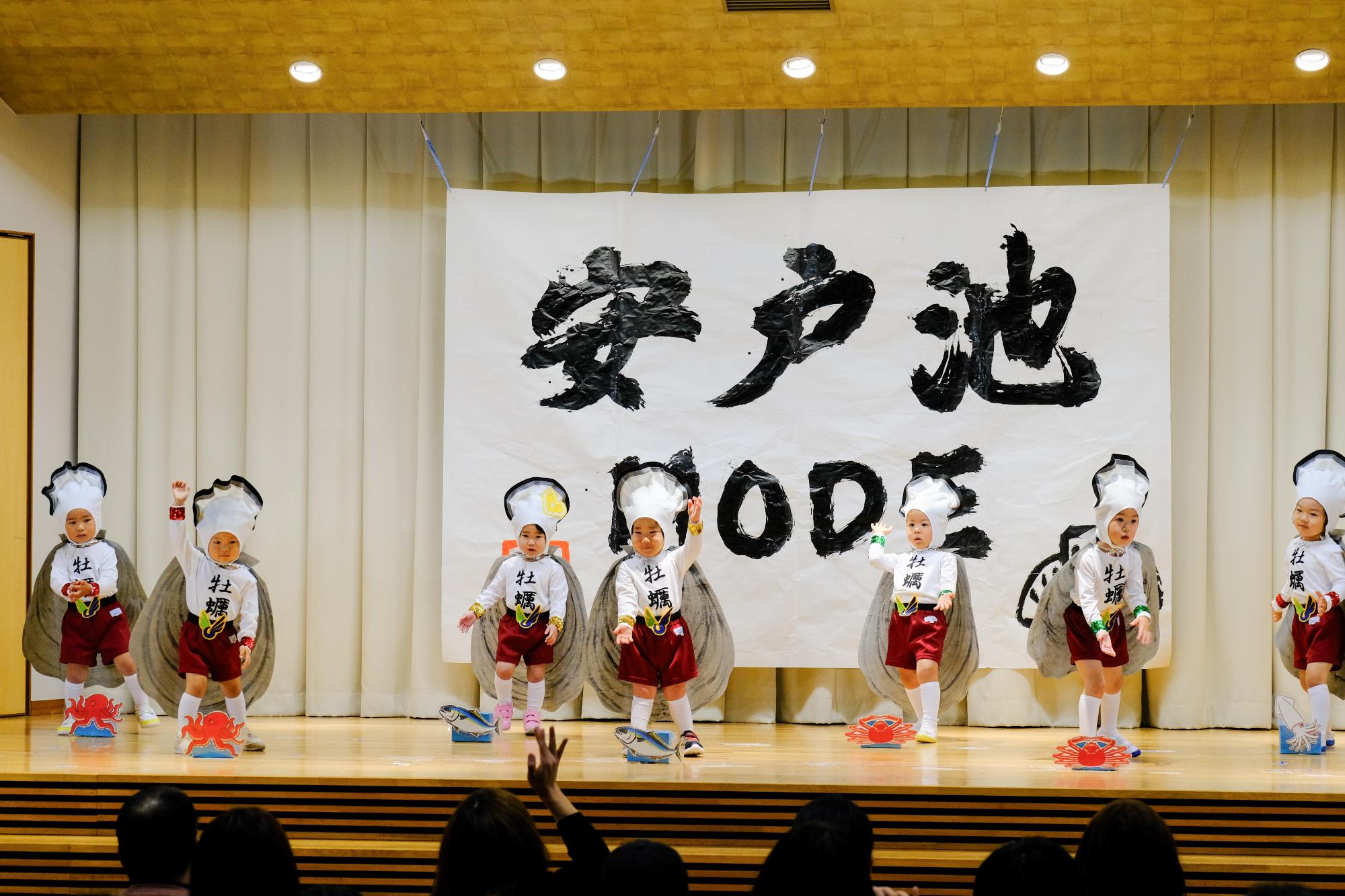 三本松高校書道部の作品の前で踊る子どもたち