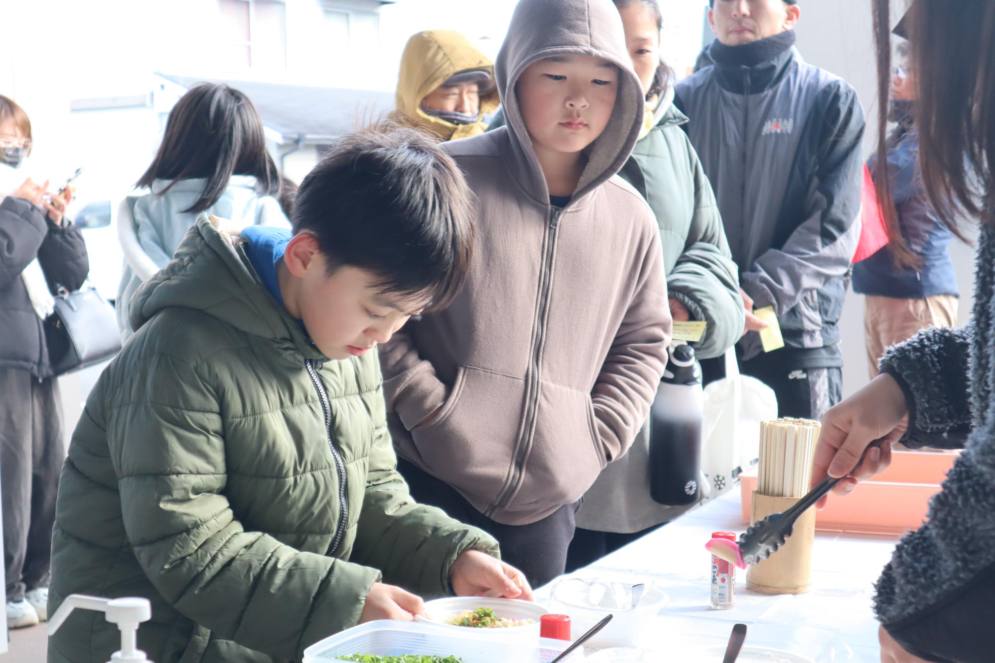 温かいうどんに並ぶ人