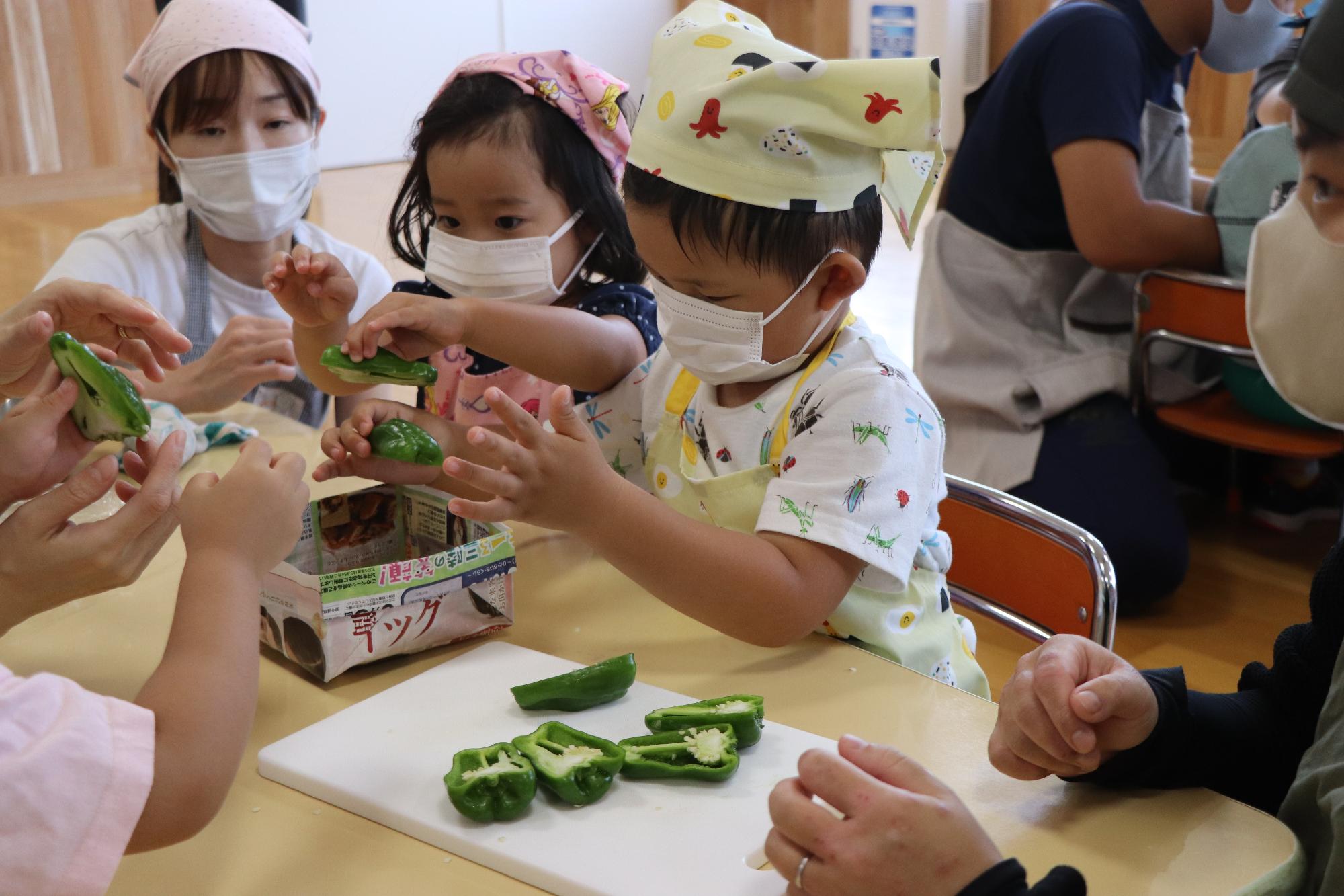 ピーマンのたねを取り除く園児