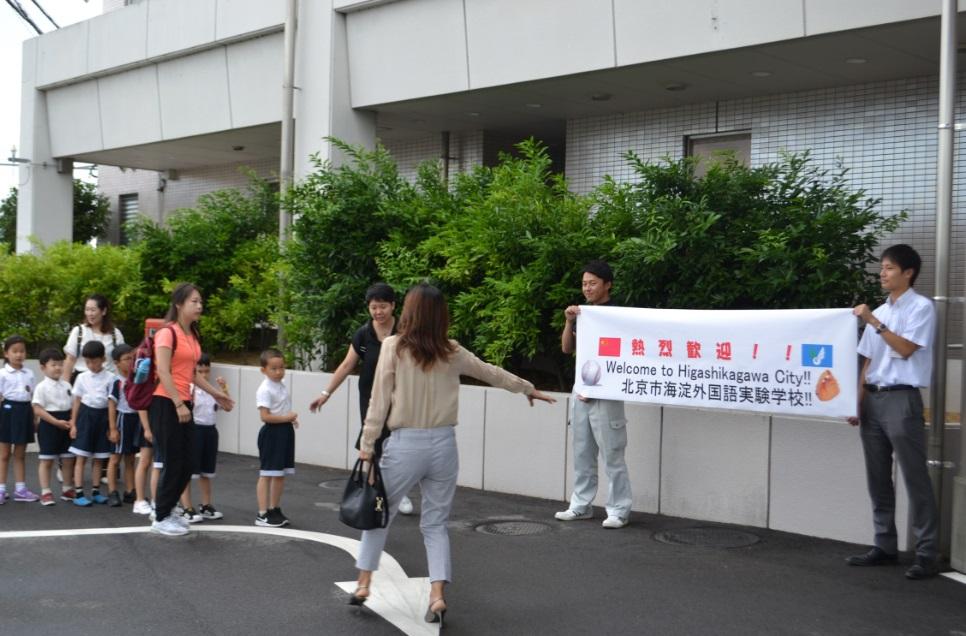歓迎の横断幕を見つめる表敬訪問に訪れた中国の子供たちの写真