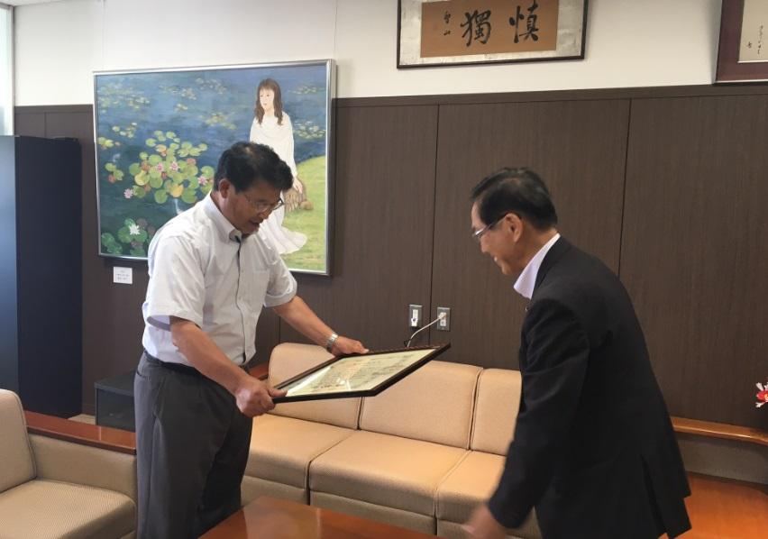 表彰状伝達式を執り行っている市長と日本赤十字社香川県支部の川部事務局長の写真