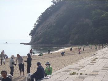 浜辺で清掃活動している参加者らの写真