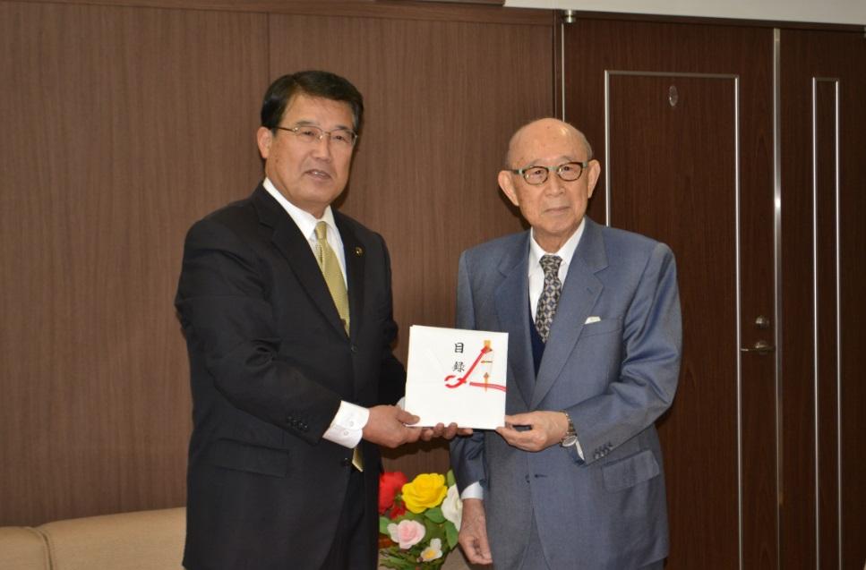 目録に手を添えた帝國製薬株式会社の社主赤澤庄三氏と市長の記念写真