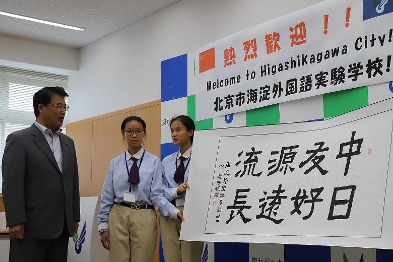 中国語で書かれた生徒たちからのメッセージを眺める市長の写真