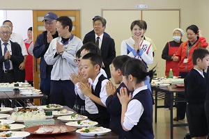 お刺身の試食前に手を合わせて頂きますをする児童たちの写真