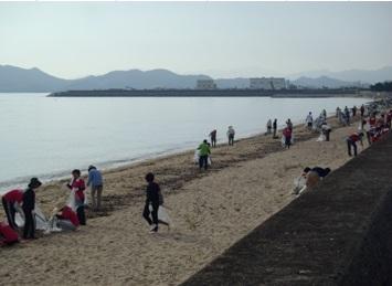 清掃活動している参加者らの背後に望む瀬戸内海の写真