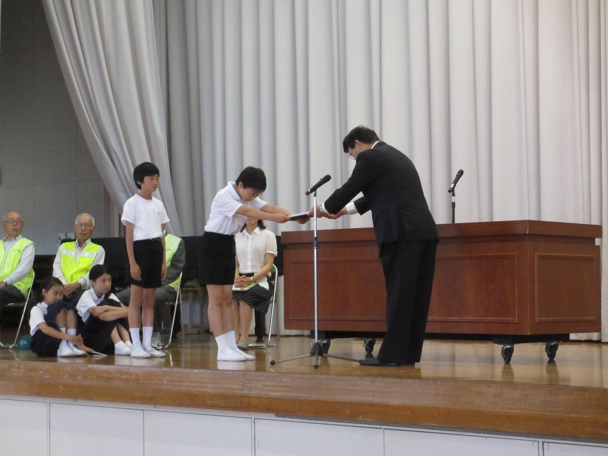 モデル校指定式にて市長が児童に賞状を手渡している様子の写真
