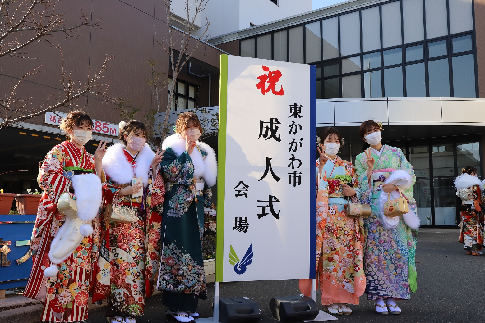 東かがわ市成人式の看板とともに記念写真をとりあう新成人方々の写真