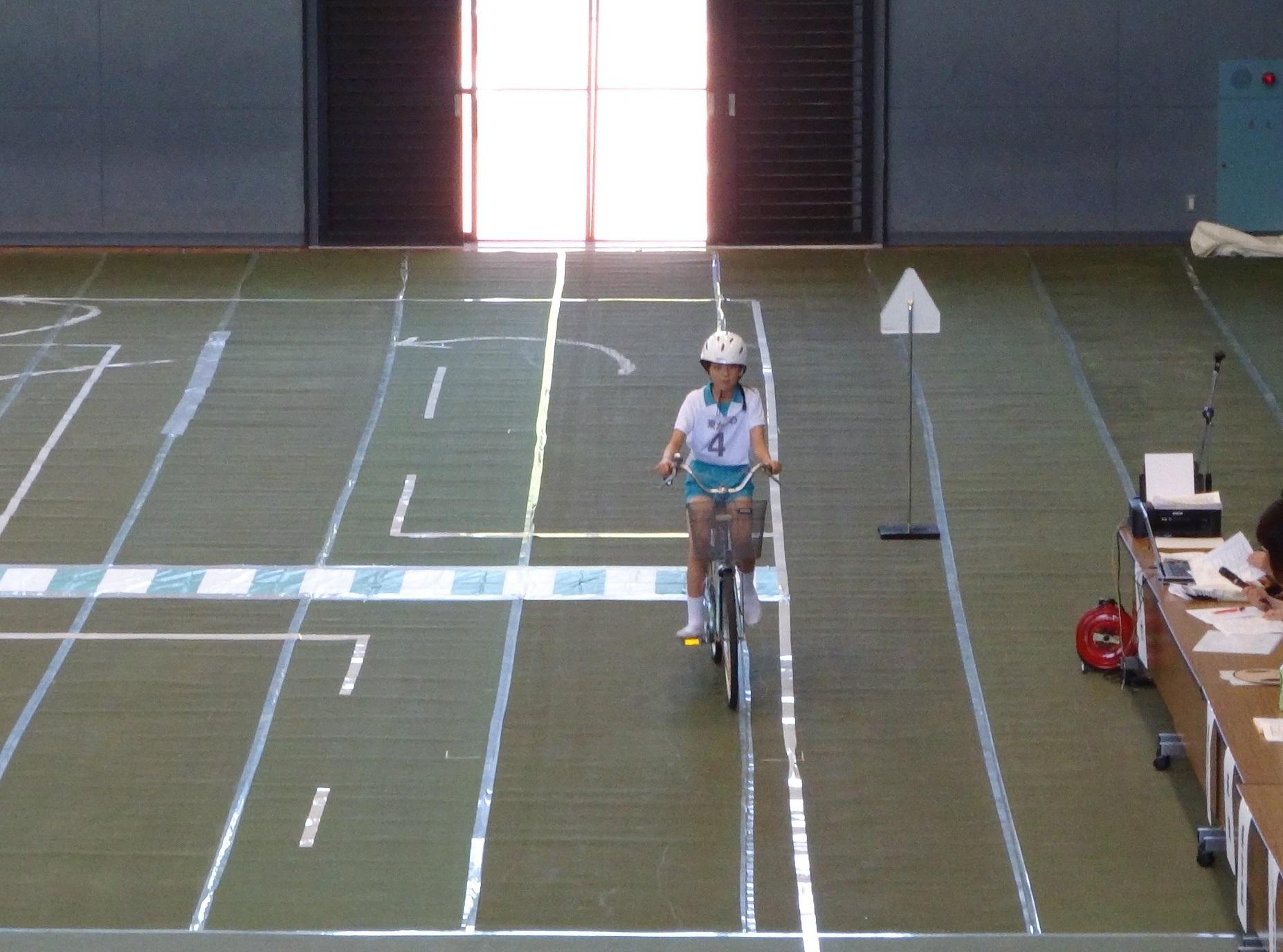県大会で選手が自転車走行の演技を披露している様子の写真