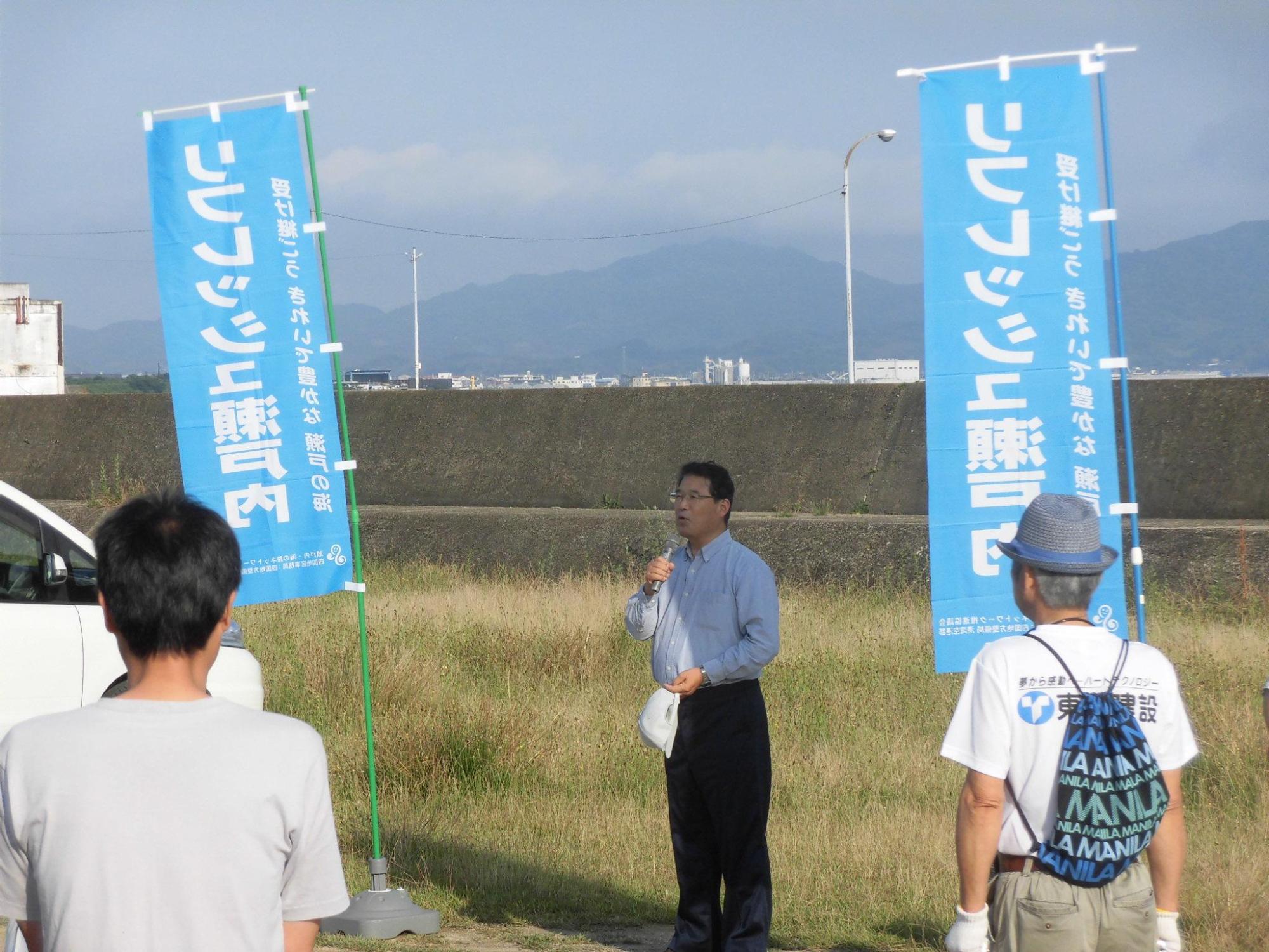 海岸清掃活動参加者たちの前で挨拶をする市長の写真
