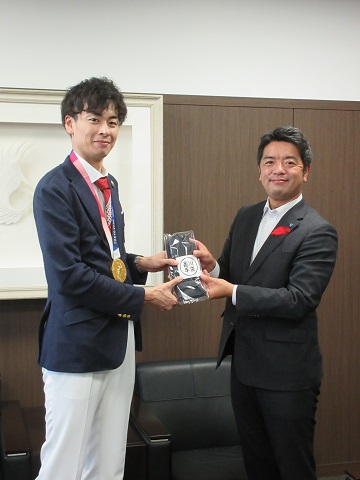 宇山選手に記念品を贈呈する市長の写真