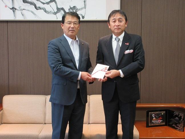 街路灯寄贈の目録に手を添えた四国電力株式会社の代表者と市長の記念写真