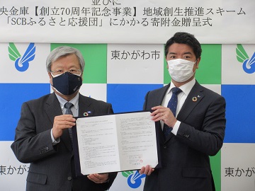 署名した協定書をもつ高松信用金庫理事長と市長の写真