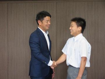 市長と上村明武さんが笑顔で握手をしている写真