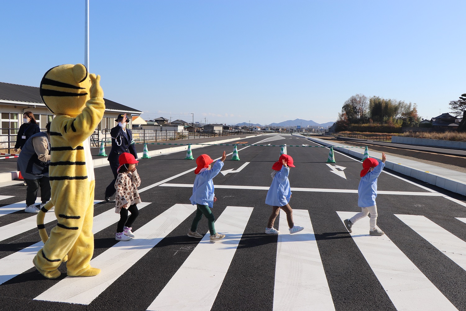 手をあげて横断歩道をわたる園児たちの様子の写真