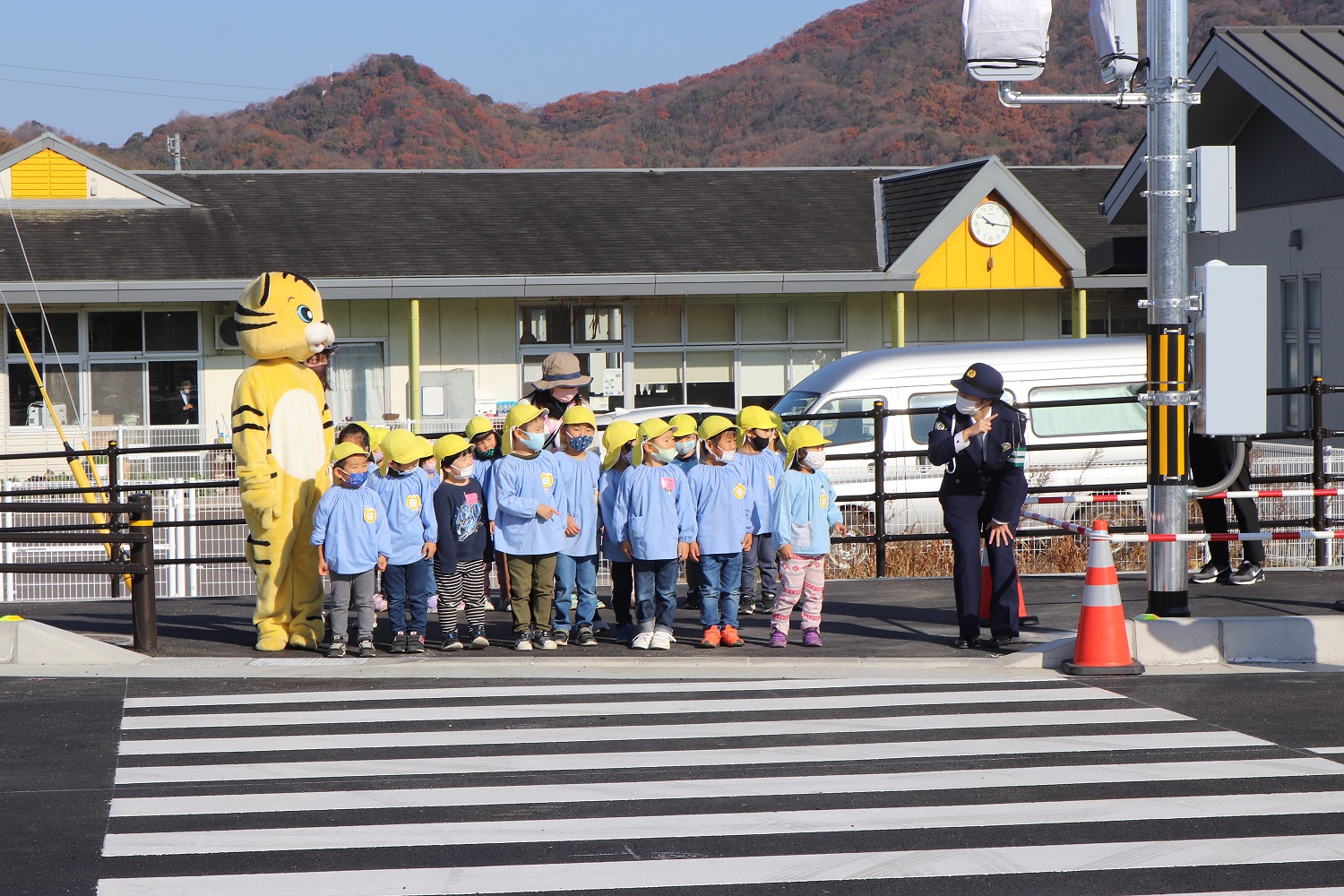 信号が青になるを待っている園児たちの写真