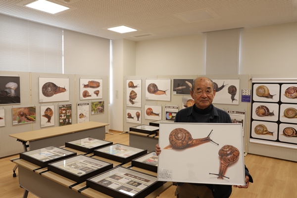アマチュア貝類研究家多田昭氏と多くのかたつむりの展示物の写真