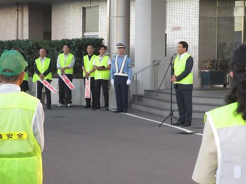 蛍光色のベストを身に着けた市長が交通安全の挨拶をする写真