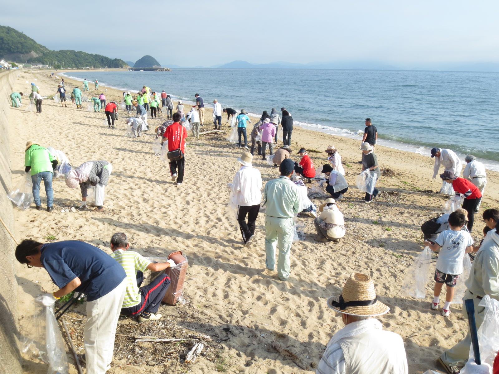 浜辺の清掃をしている参加者らの写真