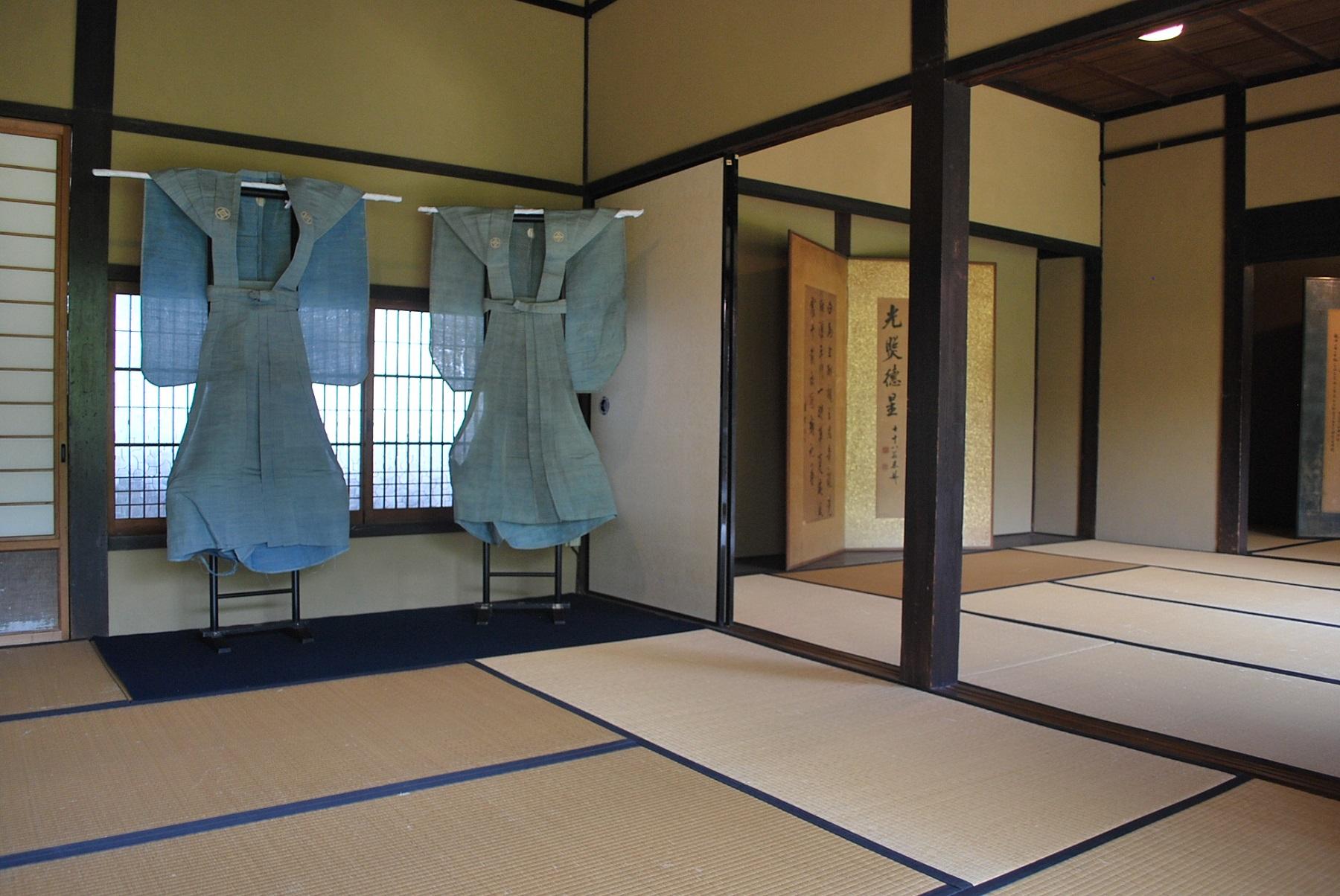 讃州井筒屋敷の畳続きの広い部屋に紋付き裃が2着かけられている様子の写真